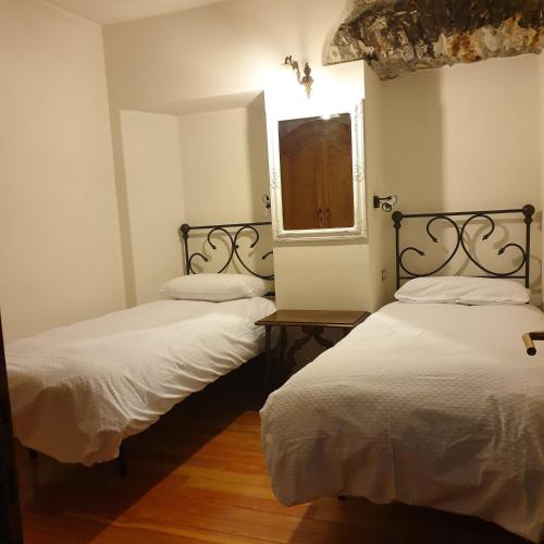 2 camas individuais num quarto com uma janela em Appartamento Dimora in Piazza -Locazione Turistica Santa Maria Maggiore em Santa Maria Maggiore