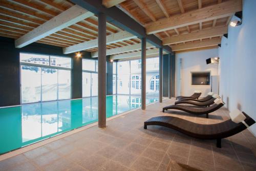 ein Zimmer mit einem Pool und einer Reihe von Stühlen in der Unterkunft Village Club La Pulka Galibier - Neaclub in Valloire