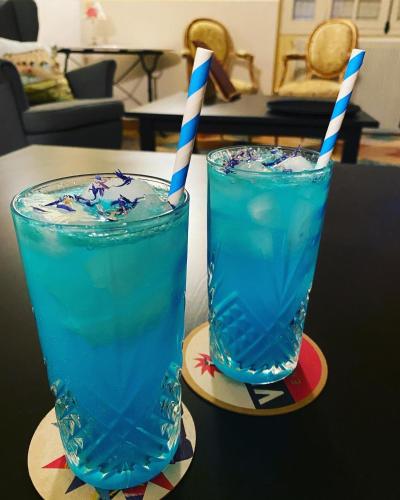 two glasses of blue liquid sitting on a table at Sans Souci Bed and Breakfast Luxe Heated Pool and Restaurant in Luzillé