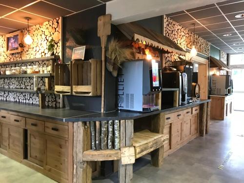 un bar avec un comptoir noir et des armoires en bois dans l'établissement Village Club La Pulka Galibier - Neaclub, à Valloire