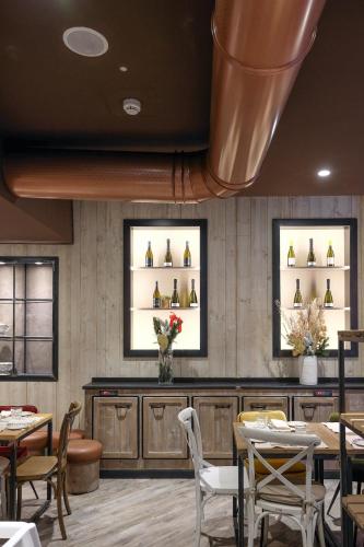 a restaurant with tables and chairs and shelves of wine bottles at Matilde Boutique Hotel in Milan
