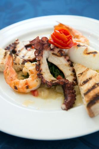 a white plate of food with shrimp and other foods at Pizzomunno Vieste Palace Hotel in Vieste