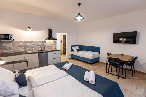 a bedroom with a bed and a kitchen with a table at Benátky 214 in Vranov nad Dyjí
