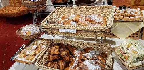 a display of bread and pastries in baskets on a table at Hotel Castel Latemar in Carezza al Lago