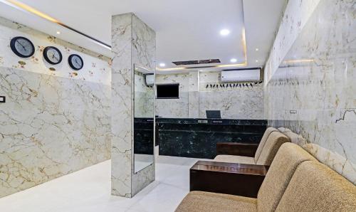 una hall con due sedie e orologi appesi al muro di Itsy Hotels J A Royal Suites Manikonda a Hyderabad