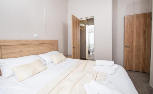 a bedroom with a large bed with white sheets and pillows at Marine Holiday Park in Rhyl