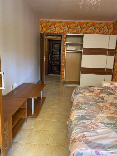 1 dormitorio con cama y escritorio de madera en Апартаментна 2 мин от плажа, en Ravda