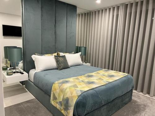 a bedroom with a bed and a large window at Apartamento Prestige Tondela in Tondela