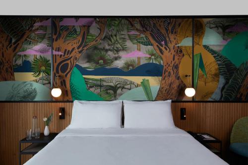 1 dormitorio con 1 cama y un mural de árboles en Drawing House en París