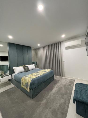 a bedroom with a large bed and a couch at Apartamento Prestige Tondela in Tondela