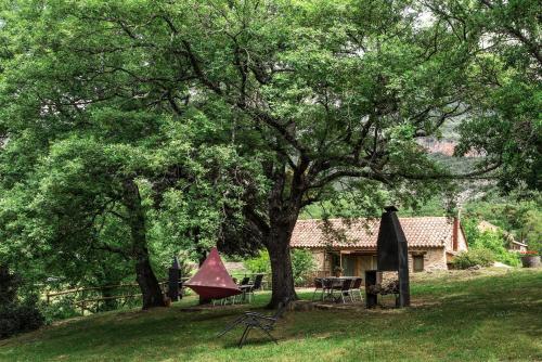 a house with a picnic table and a tree at Casas Rurales Molinias in Fosado