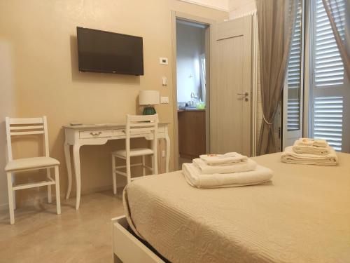 a bedroom with a bed and a desk and a television at Dimora della Nonna in Mola di Bari