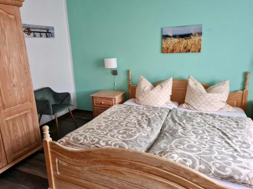 een slaapkamer met een bed met een blauwe muur bij Ravensbergblick - harzlich willkommen in Bad Sachsa in Bad Sachsa
