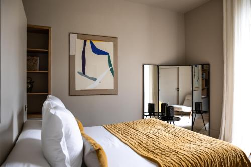 a bedroom with a bed and a mirror at Maison Aribert in Saint-Martin-dʼUriage