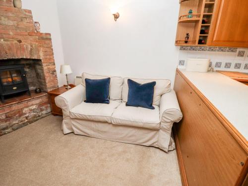 a living room with a couch with two blue pillows at 5A Waterfall Way in Market Harborough