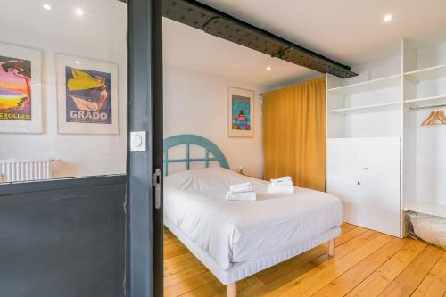 - une chambre avec un lit et une porte menant à une pièce dans l'établissement Le Corbeau et le Homard, un vrai havre de paix, à Dijon