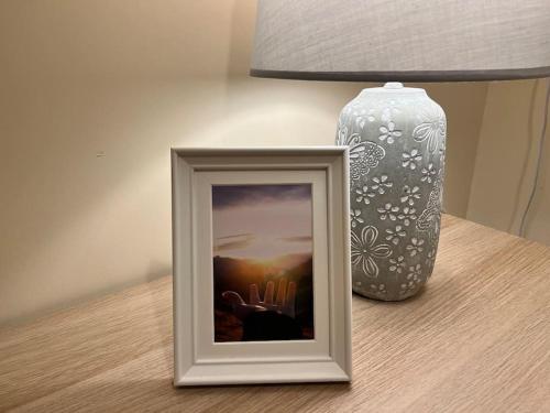 a picture on a table next to a lamp and a vase at 18 The Mullins in Donegal