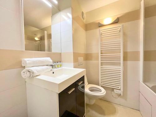 een witte badkamer met een wastafel en een toilet bij T2 au cœur du centre historique de Briançon #3 in Briançon