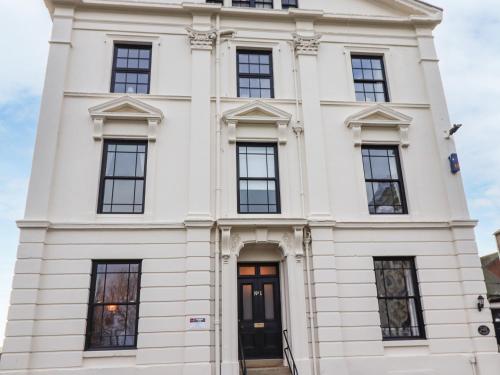 a white building with black doors and windows at Number One The Crescent in Filey