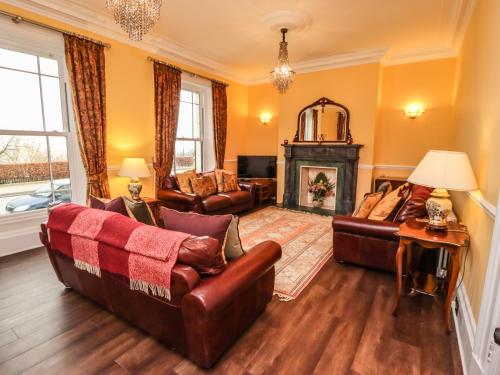 a living room with leather furniture and a fireplace at Number One The Crescent in Filey