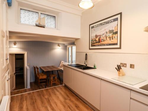 a kitchen with a counter top and a table at Number One The Crescent in Filey