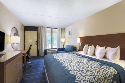 a hotel room with a bed and a desk at Days Inn by Wyndham Newark Wilmington in Newark