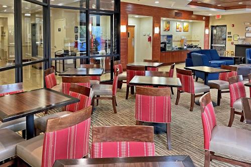 un restaurante con mesas y sillas y un bar en Comfort Suites Augusta Riverwatch, en Augusta