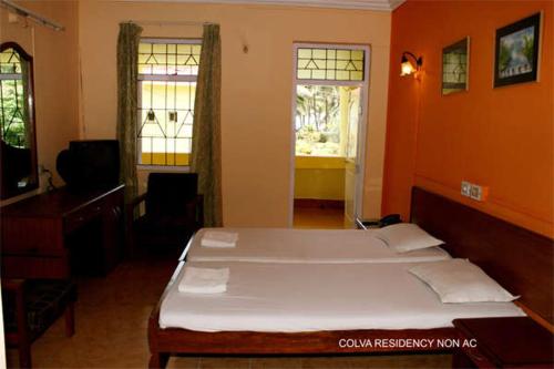 een slaapkamer met een groot bed in een oranje kamer bij Colva Residency in Colva