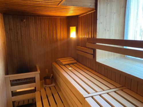 a wooden sauna with a bench and a window at Hotel Castel Latemar in Carezza al Lago