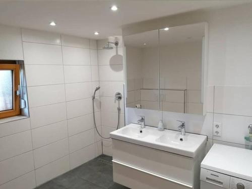 biała łazienka z umywalką i prysznicem w obiekcie Stockerhof w mieście Elzach