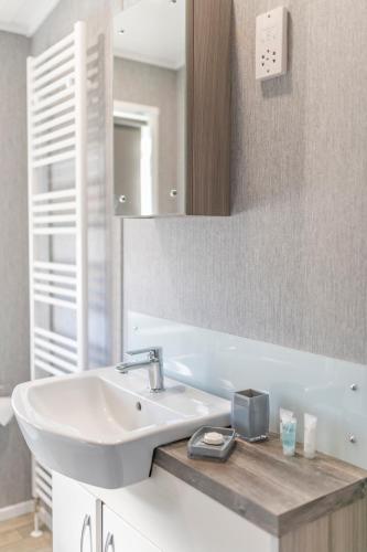 a bathroom with a white sink and a mirror at Marine Holiday Park in Rhyl