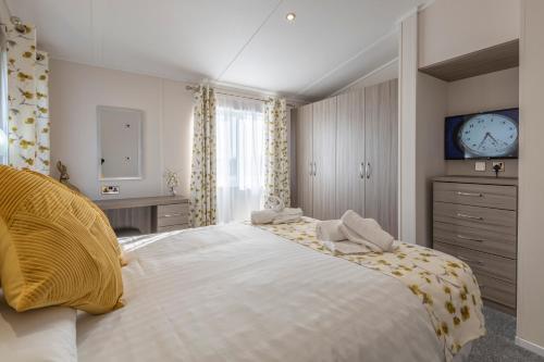 a bedroom with a large bed and a clock on the wall at Marine Holiday Park in Rhyl