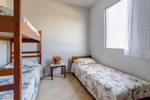 a bedroom with two beds and a bunk bed at Praia de Itapirubá in Imbituba