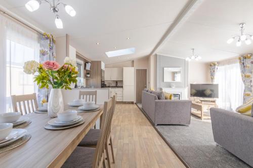 a dining room and living room with a table and chairs at Marine Holiday Park in Rhyl
