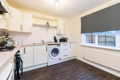 a kitchen with a washer and dryer in it at 3-Bed House in Coventry with Free Parking & Private Garden By Sublime Stays in Parkside