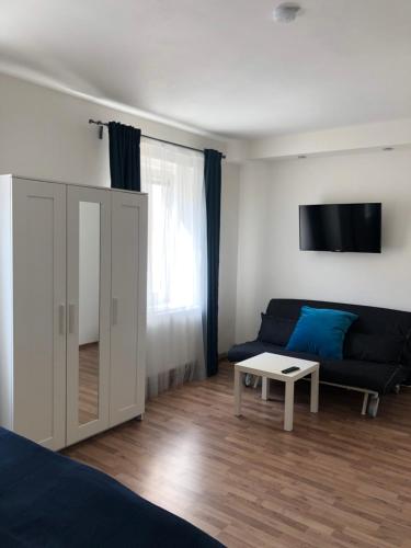 ein Wohnzimmer mit einem blauen Sofa und einem Tisch in der Unterkunft Penzion Nový Svět in Krásno