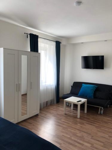 a living room with a blue couch and a table at Penzion Nový Svět in Krásno