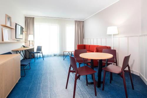 a hotel room with tables and chairs and a couch at Holiday Inn Gdansk - City Centre by IHG in Gdańsk