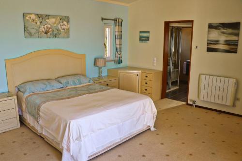 a bedroom with a bed and a bathroom with a shower at Villa Santa Barbara by Portucasa in Bordeira