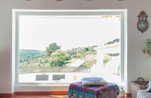 ventana grande en una habitación con mesa y taburete en Akivillas Ericeira Charm, en Santo Isidoro