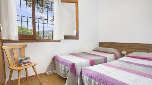 リョレート・デ・マルにあるVilla Montecarloのベッドルーム1室(ベッド2台、窓付)