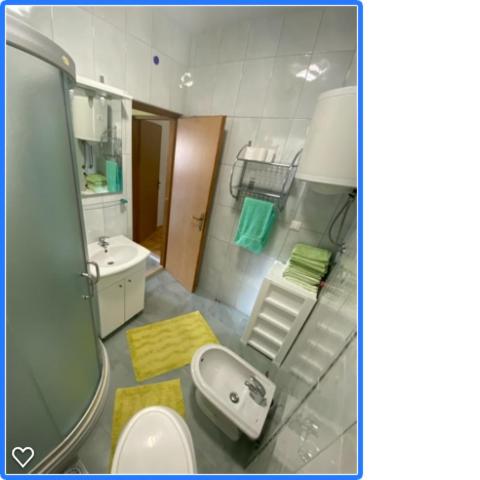 a bathroom with a sink and a toilet and a mirror at DaMa in Obrovac