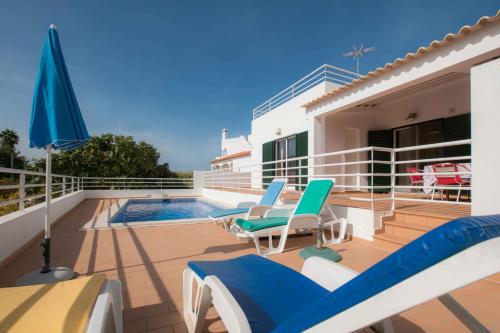 a patio with chairs and an umbrella and a swimming pool at Casa da Alcaria by Portucasa in Altura