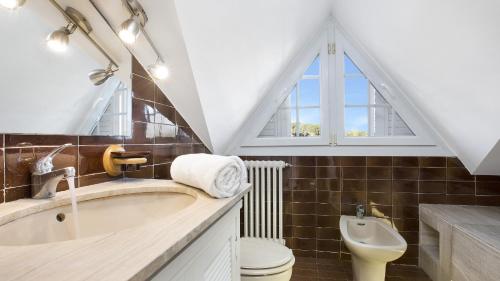a bathroom with a sink and a toilet and a window at 2Monte01 - Blanes in Blanes