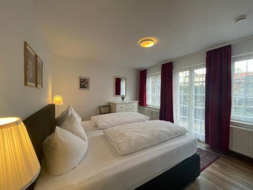 - une chambre avec 2 lits, une lampe et des fenêtres dans l'établissement Apartment mit Terrasse No1, à Quedlinbourg