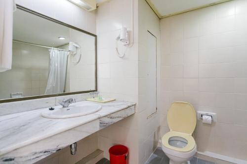 a bathroom with a sink and a toilet and a mirror at Hadthong Hotel in Prachuap Khiri Khan