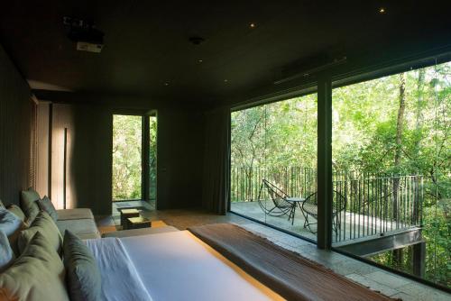 - une chambre avec un lit et une grande fenêtre dans l'établissement Rio Perdido Hotel & Thermal River, à Fortuna