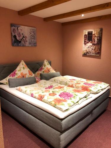 a bedroom with a bed with a floral blanket at Ferienwohnung & Pension Brückner in Auma