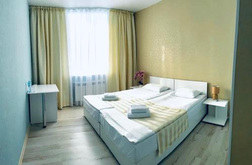 a bedroom with a large white bed and a window at Sergeev Hotel in Mykolaiv