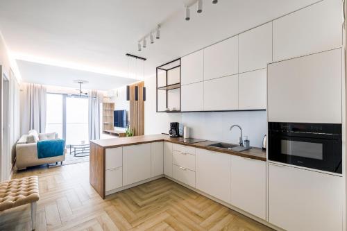 a white kitchen with a sink and a stove at Balticus Apartamenty Deluxe Promenada Gwiazd 14 in Międzyzdroje